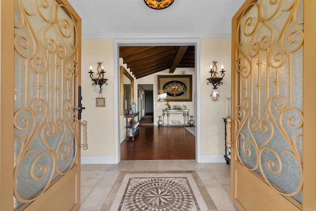 entryway featuring lofted ceiling with beams and baseboards