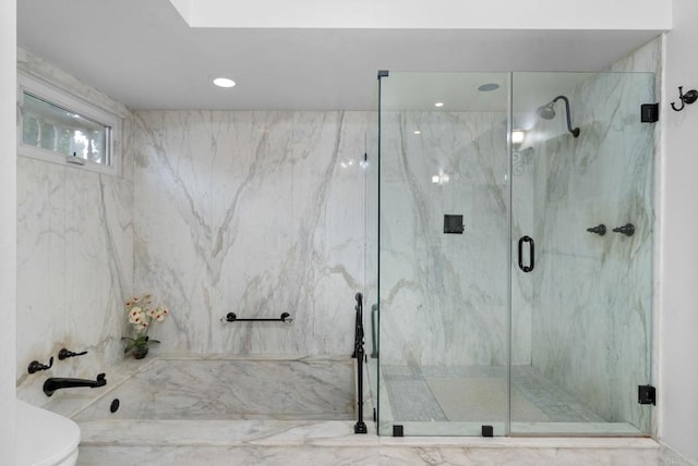 bathroom featuring toilet and a marble finish shower