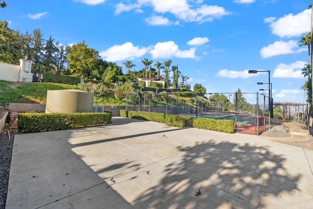 exterior space featuring a tennis court and fence