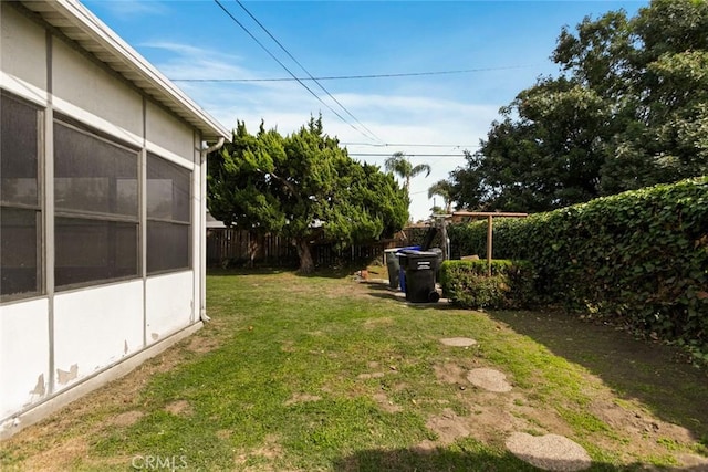 view of yard featuring a sunroom and fence