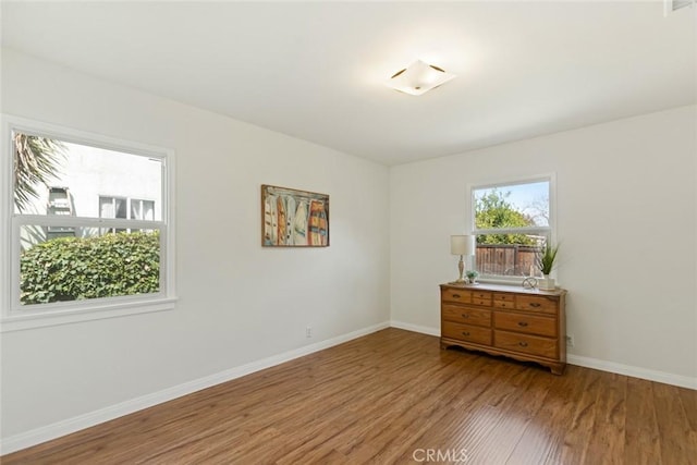 empty room featuring baseboards and wood finished floors