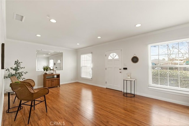 entrance foyer with light wood finished floors, visible vents, and a healthy amount of sunlight