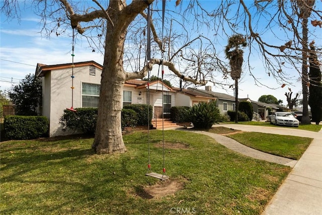 view of front of house featuring stucco siding and a front lawn