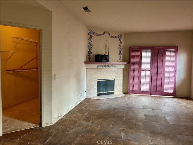 unfurnished living room featuring visible vents and a fireplace