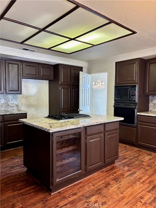 kitchen featuring black appliances, beverage cooler, a center island, dark brown cabinets, and dark wood-style flooring