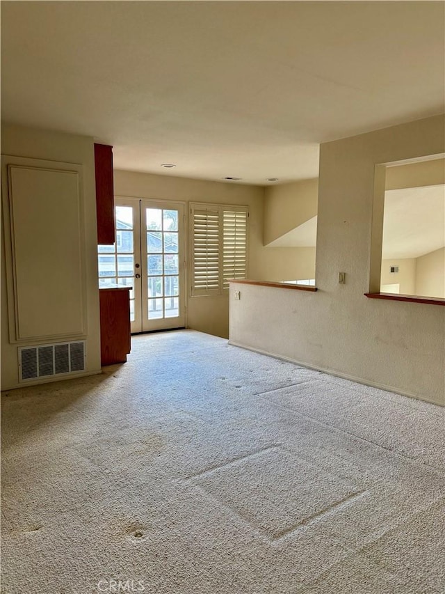 carpeted empty room featuring visible vents and french doors