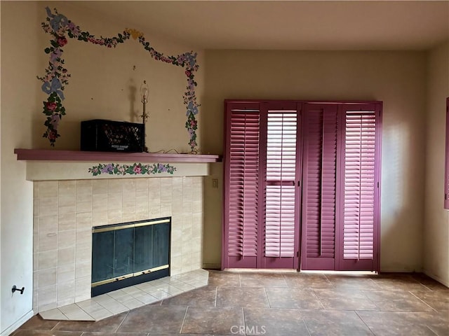 unfurnished living room featuring plenty of natural light and a tile fireplace