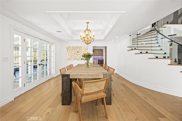 dining room featuring light wood-type flooring, stairway, ornamental molding, and french doors