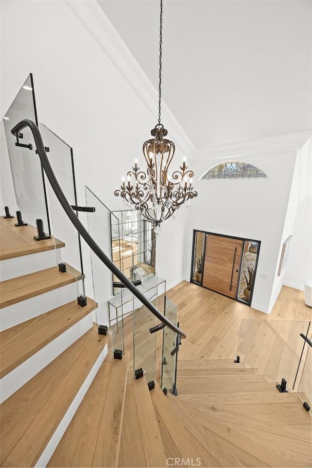 stairway with crown molding and wood-type flooring