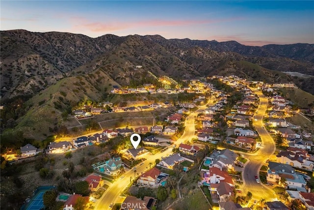 aerial view at dusk featuring a residential view and a mountain view