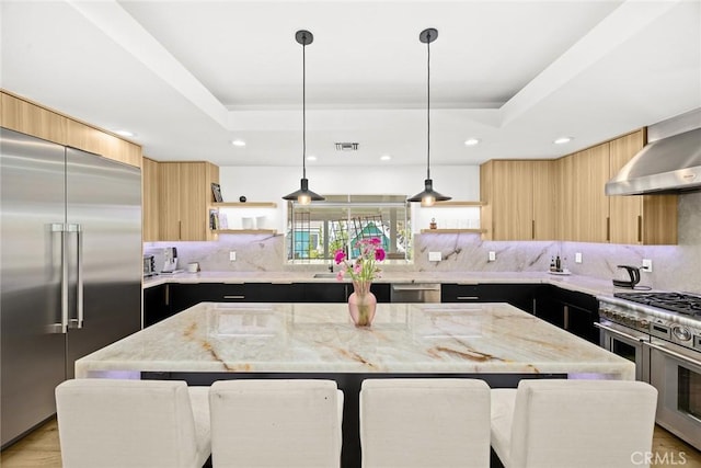 kitchen featuring light brown cabinetry, high quality appliances, modern cabinets, a raised ceiling, and open shelves