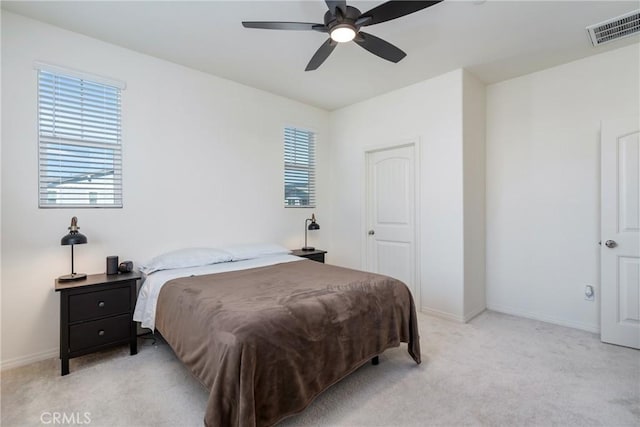 bedroom featuring visible vents, light colored carpet, a ceiling fan, and baseboards