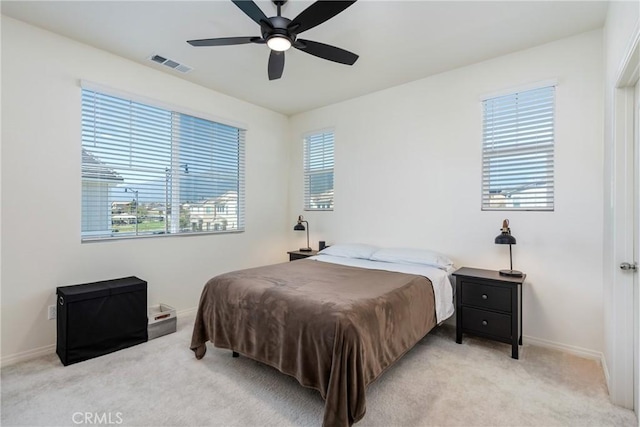 bedroom featuring visible vents, light carpet, and multiple windows