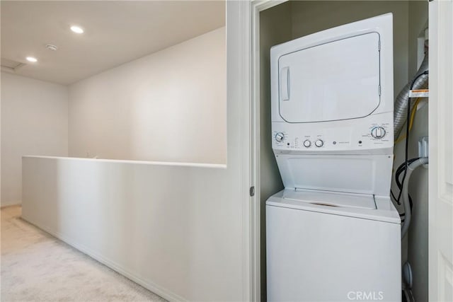 laundry room with recessed lighting, stacked washer / drying machine, carpet floors, and laundry area