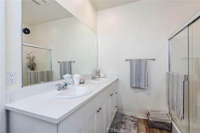 full bathroom featuring double vanity, visible vents, a shower stall, and a sink