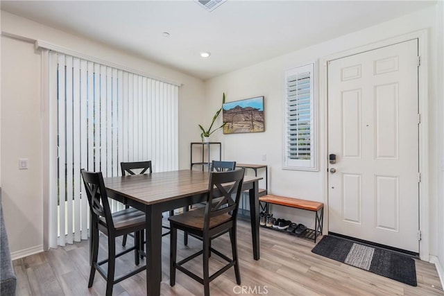 dining room with recessed lighting, light wood-style flooring, and baseboards