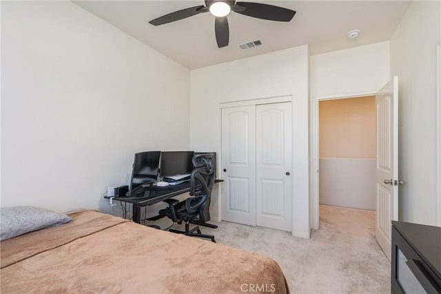 bedroom with visible vents, light carpet, a closet, and a ceiling fan