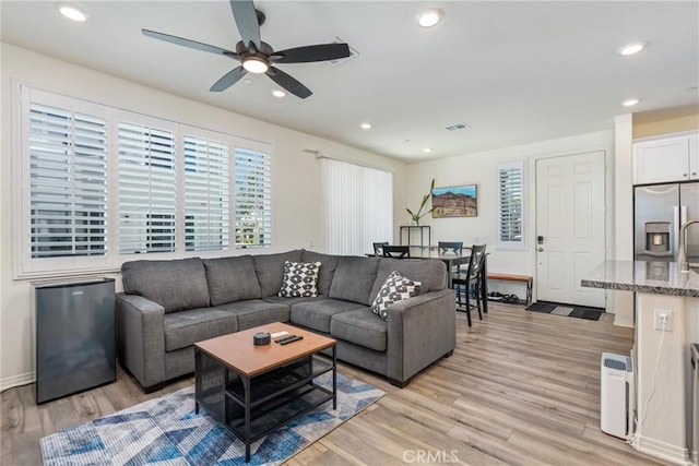 living area with light wood finished floors, visible vents, baseboards, recessed lighting, and a ceiling fan