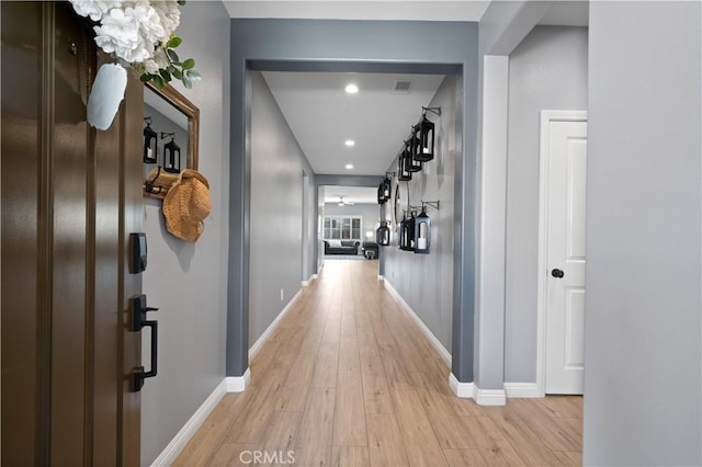 corridor with baseboards and light wood-style floors