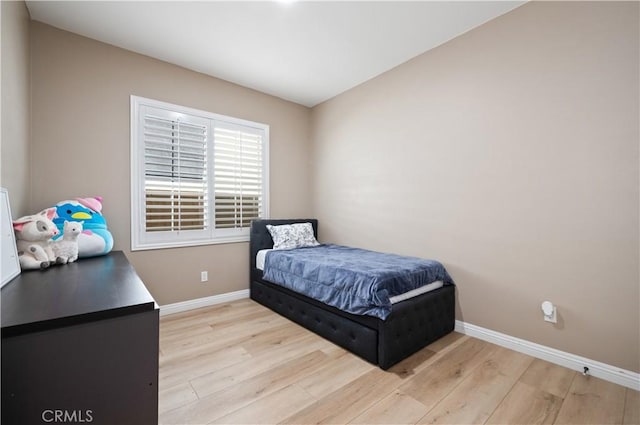 bedroom with light wood-type flooring and baseboards