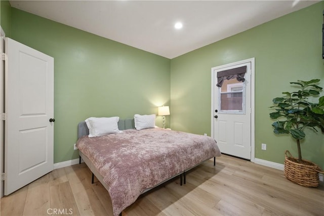 bedroom with baseboards and light wood finished floors