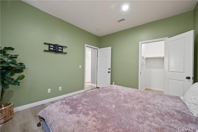 bedroom featuring visible vents, baseboards, and wood finished floors