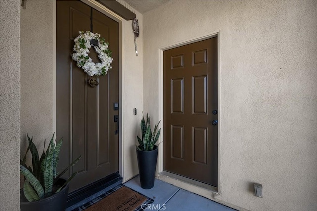 doorway to property featuring stucco siding