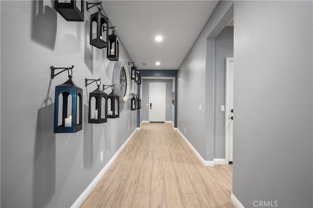 hallway featuring recessed lighting, baseboards, and light wood-style floors