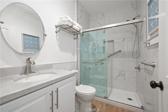 full bathroom featuring vanity, toilet, wood finished floors, and a shower stall