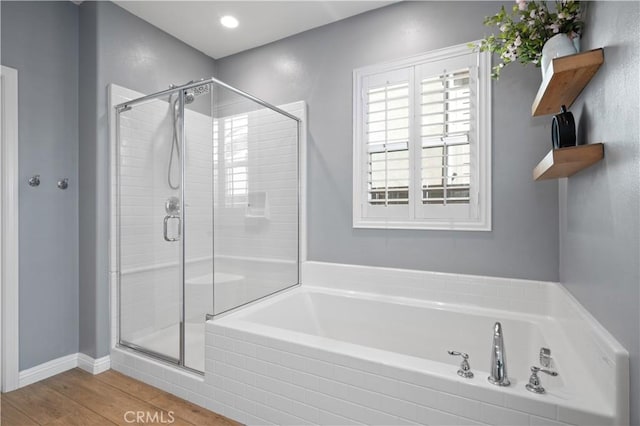 full bathroom featuring a garden tub, wood finished floors, and a shower stall