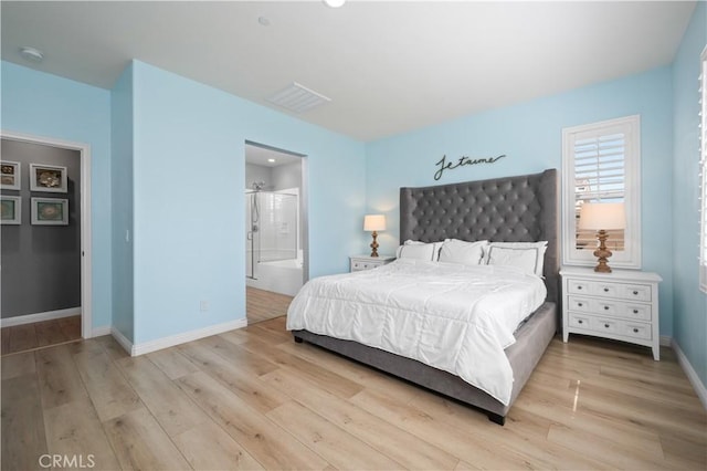 bedroom featuring visible vents, baseboards, ensuite bath, and light wood finished floors