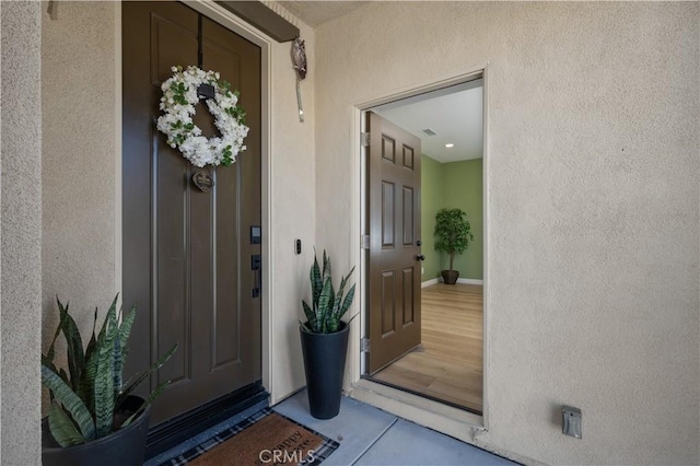 entrance to property featuring stucco siding