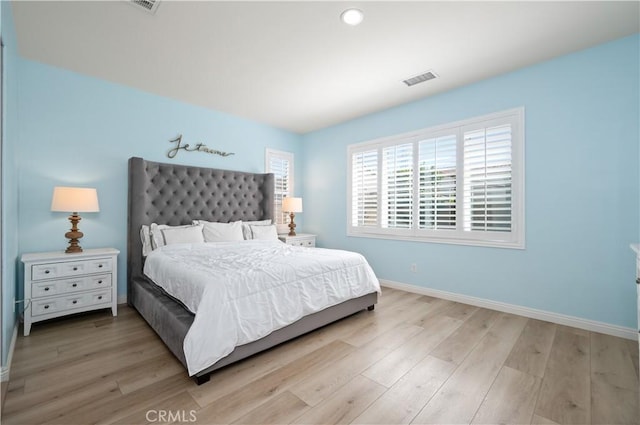 bedroom with visible vents, baseboards, and light wood-style flooring