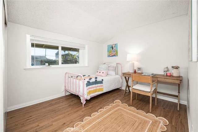 bedroom with lofted ceiling, wood finished floors, baseboards, and a textured ceiling