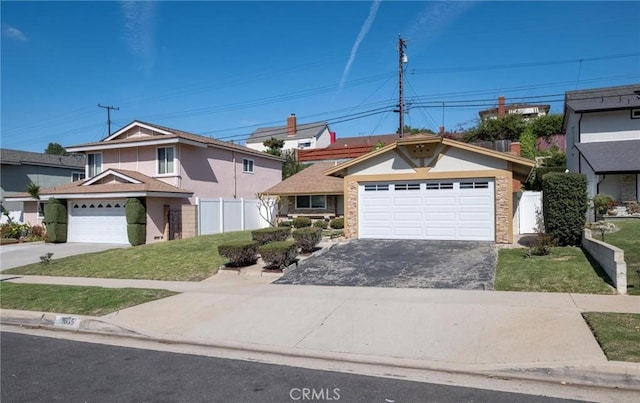 traditional-style home with a front lawn, fence, and driveway