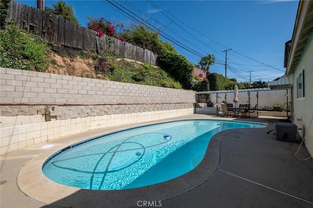 view of swimming pool featuring a patio, outdoor dining area, a fenced backyard, and a fenced in pool