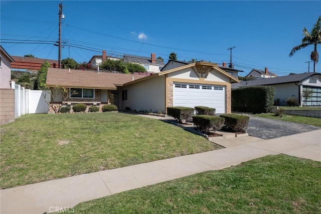 single story home with a front yard, fence, driveway, an attached garage, and stucco siding