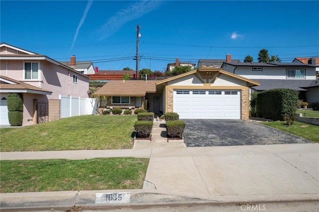 view of front facade featuring driveway, an attached garage, a front yard, and fence