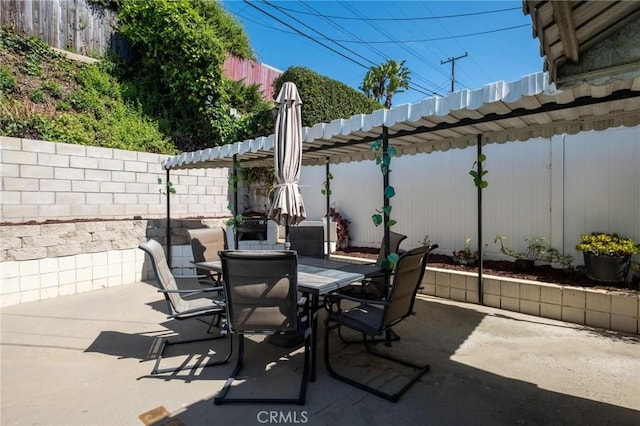 view of patio / terrace with a pergola, outdoor dining area, and fence