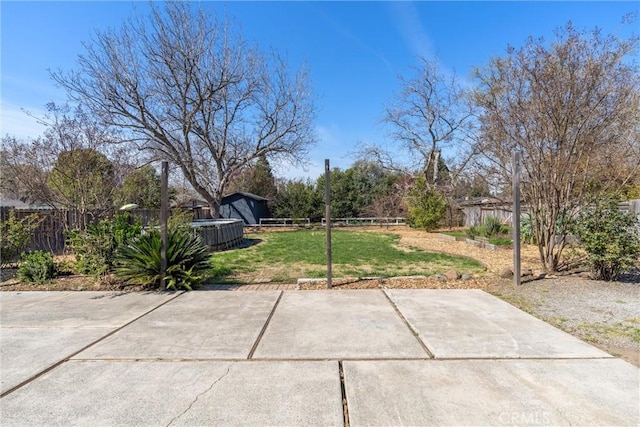 view of yard featuring a patio area, a fenced backyard, and an outdoor structure