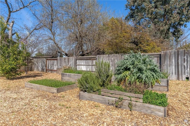 view of yard with a fenced backyard and a garden