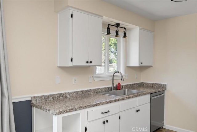 kitchen featuring stainless steel dishwasher, white cabinetry, and a sink