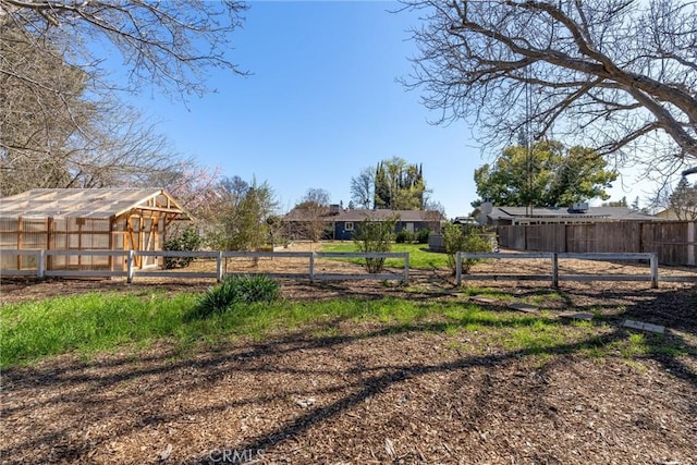 view of yard featuring an outbuilding, an exterior structure, and fence