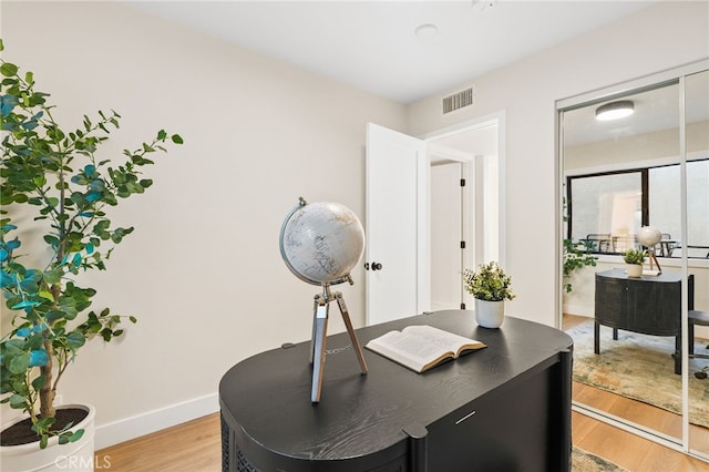 office featuring visible vents, baseboards, and light wood finished floors