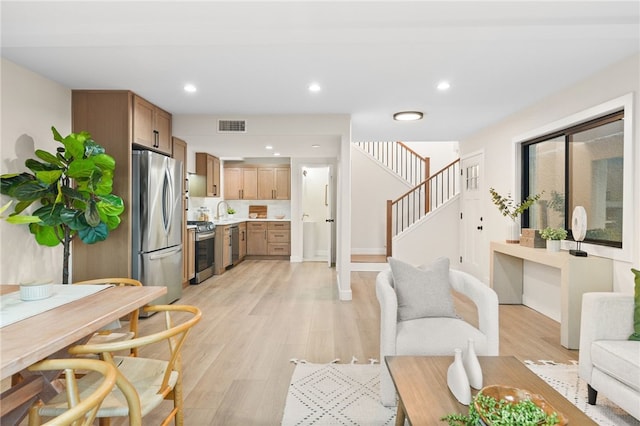 living room featuring visible vents, recessed lighting, stairway, and light wood-style floors