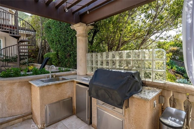 view of patio with stairway, fence, grilling area, and a sink