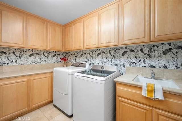 washroom featuring light tile patterned floors, wallpapered walls, cabinet space, a sink, and independent washer and dryer