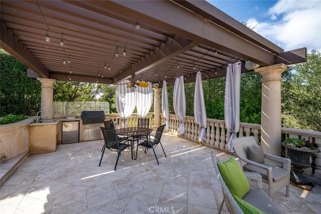 view of patio / terrace featuring a sink, an outdoor kitchen, outdoor dining space, and a grill