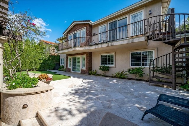 rear view of property featuring stucco siding and a patio area