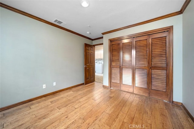 unfurnished bedroom featuring baseboards, visible vents, washer / dryer, a closet, and light wood-type flooring